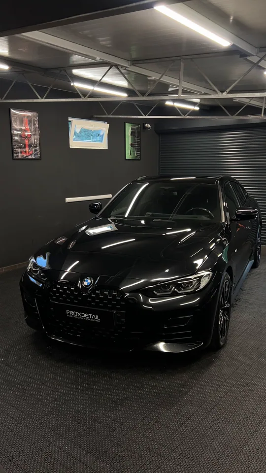 Czarne BMW z przodu, ze światłem odbitym w masce
